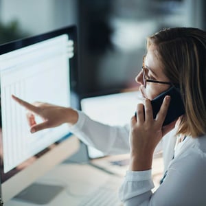 businesswoman-pointing-at-a-screen-and-talking-on-the-phone