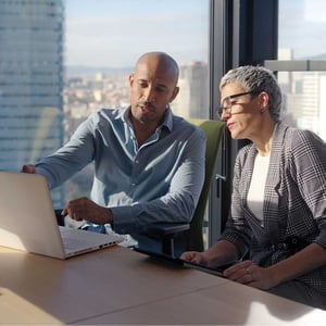male-and-female-coworker-analyze-work-on-a-laptop
