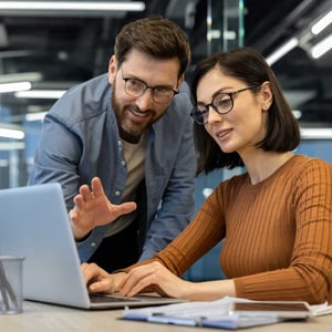 man-pointing-at-laptop-screen-woman-typing