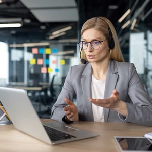 serious-focused-woman-with-headset-talking-to-colleagues-and-partners