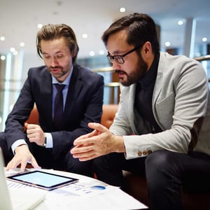 two-businessmen-showing-and-explaining-data