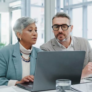 two-colleagues-discussing-problem-with-laptop