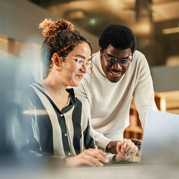 two-colleagues-using-laptop-to-discuss-work-project-office