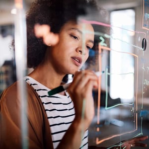 woman-working-and-writing-on-the-glass-board-in-office